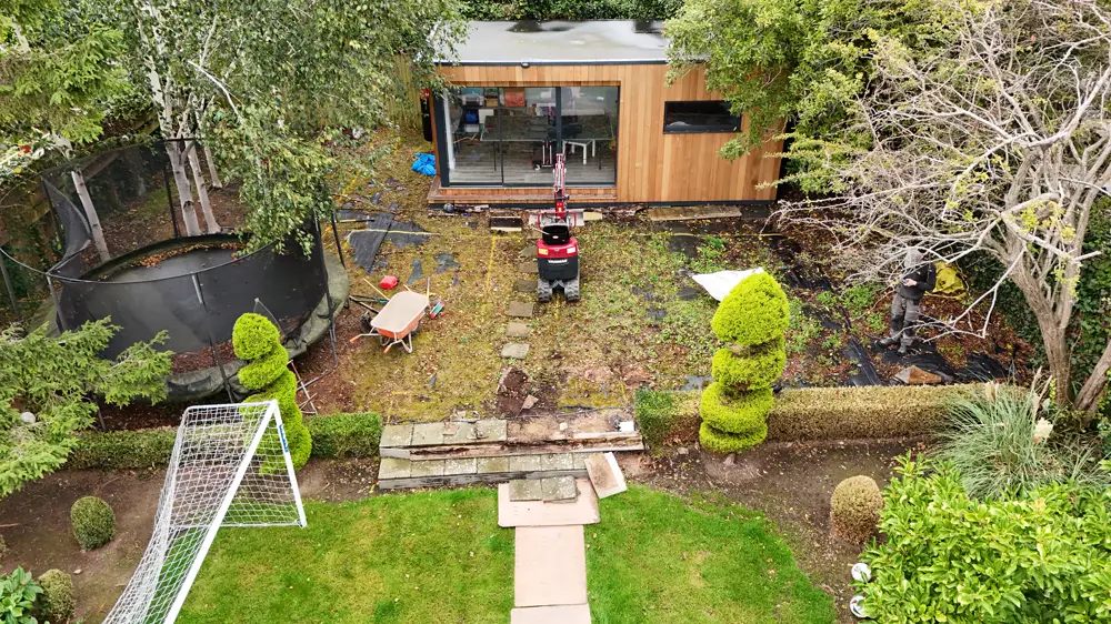 The same garden before the work: worn ground and patchy lawn.