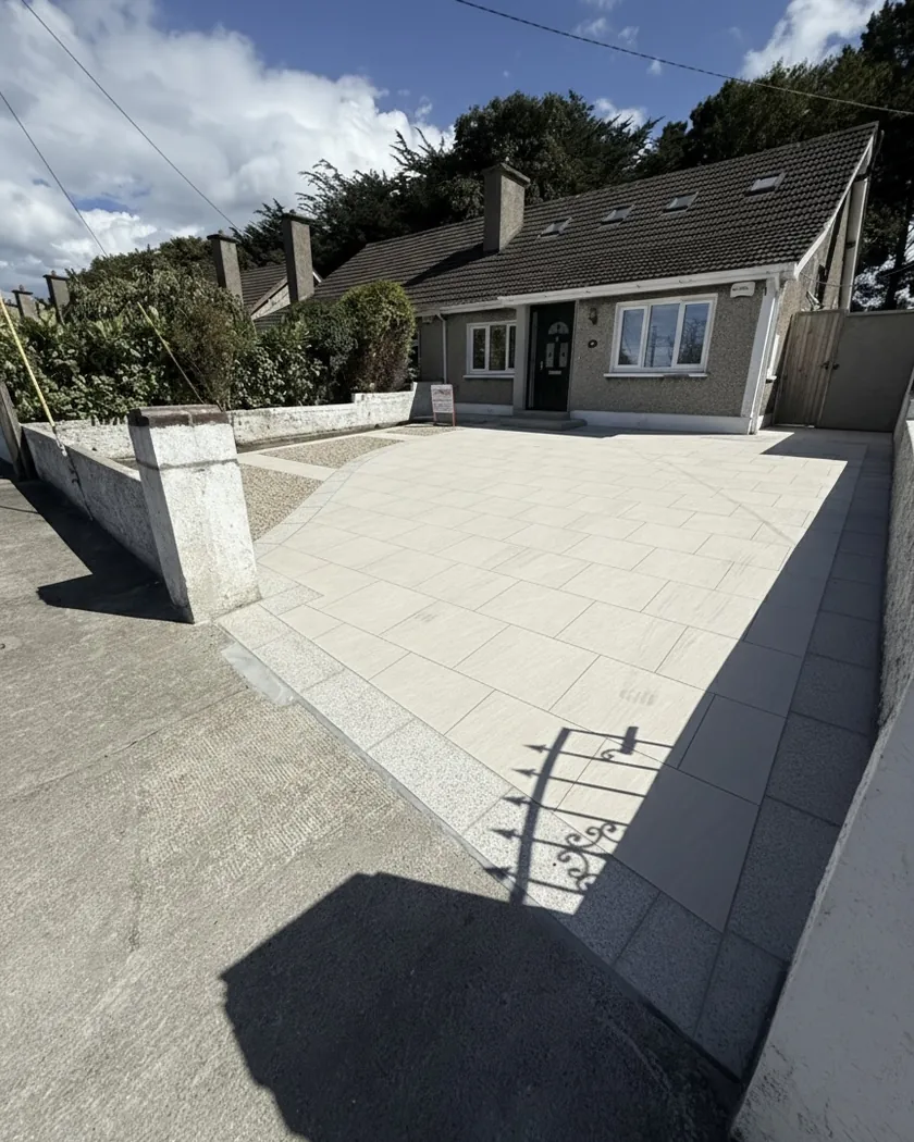 Finished porcelain driveway with granite borders outside a bungalow.